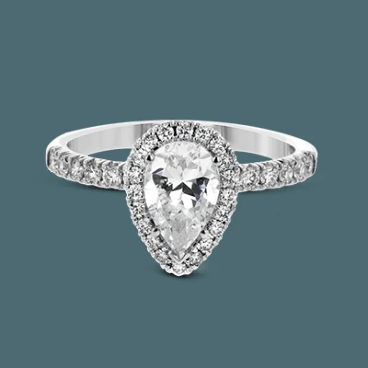 Women’s emerald cut engagement rings-This white gold wedding set is simple yet dazzling with .71 ctw of round white diamonds framing an eye-catching pear shaped centerpiece.