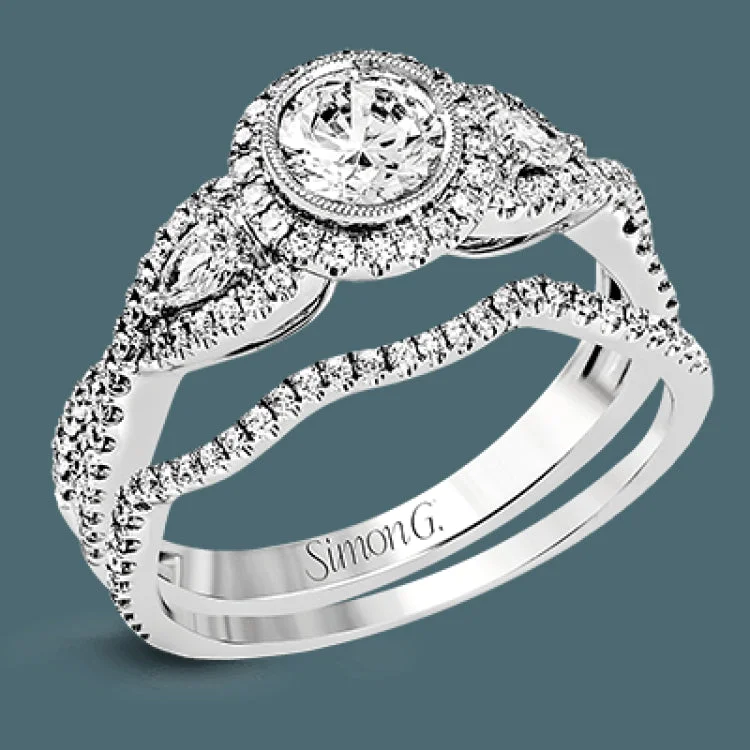 Women’s stacked engagement rings-This 18k white gold wedding set has a distinctive design with a milgrain accented bezel center stone setting, .15 ctw pear side stones, and .50 ctw of round brilliant diamonds.