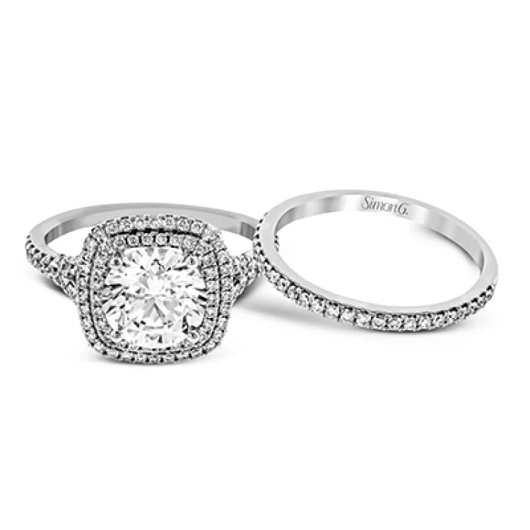 Women’s romantic engagement rings-This remarkable white gold engagement ring and wedding band set features a contemporary setting with an eye-catching halo highlighted by .67 ctw of round cut white diamonds.