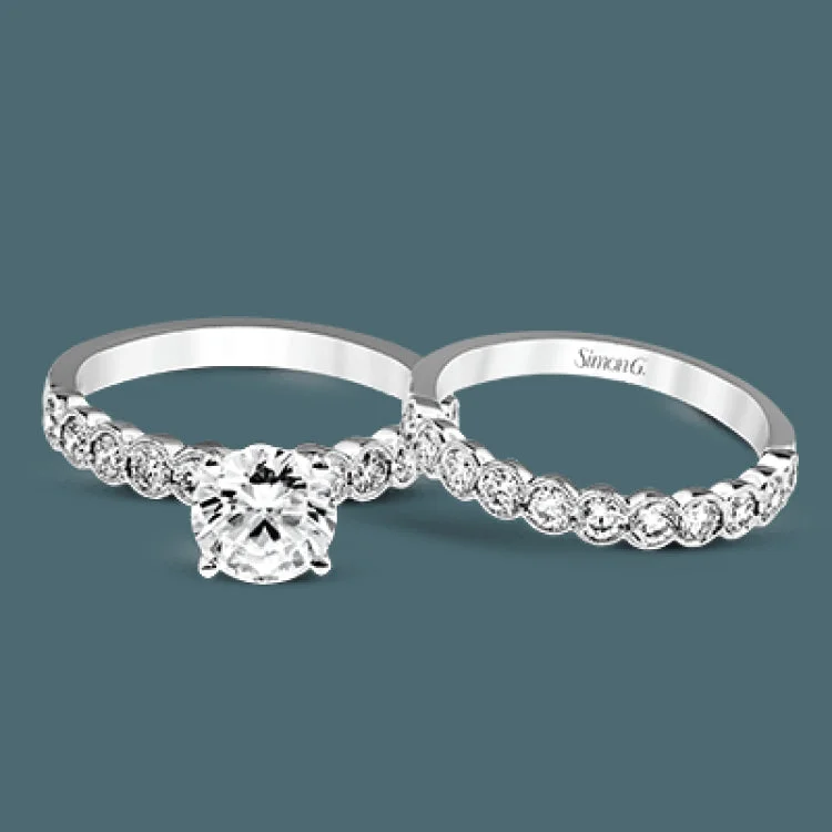 Women’s princess-cut engagement rings-This engagement and wedding band set combines old and new with 1.09 ctw of round brilliant diamonds bezel set into 18k white gold, accented with vintage-inspired milgrain.