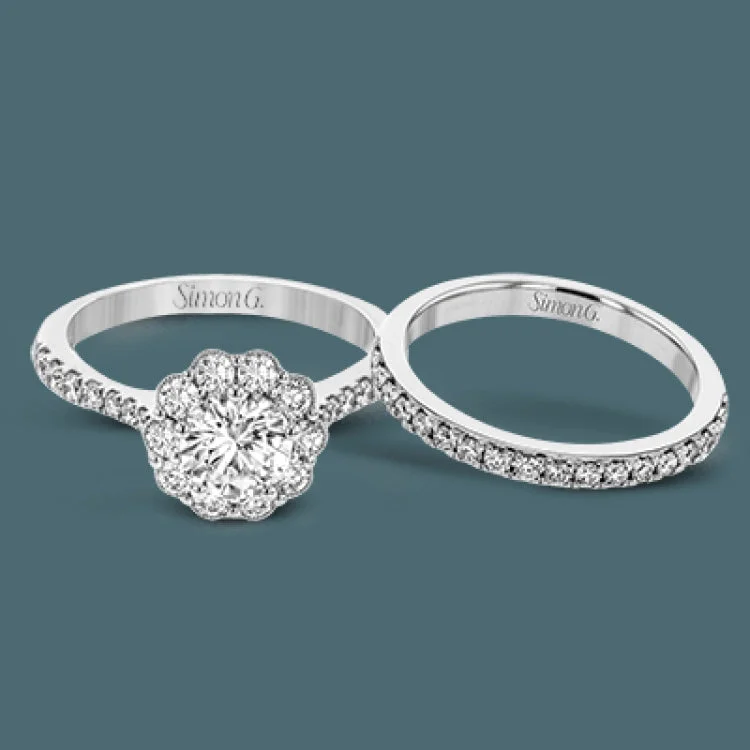 Women’s emerald solitaire engagement rings-This white gold wedding set frames its centerpiece with .90 ctw of round white diamonds in a whimsical floral-inspired design.