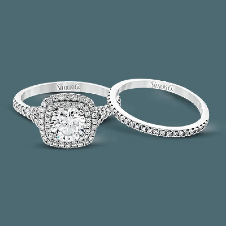 Women’s engagement rings with heart-shaped diamonds-This eye-catching contemporary white gold engagement ring and wedding band set features an impressive halo accented by .63 ctw round cut white diamonds.