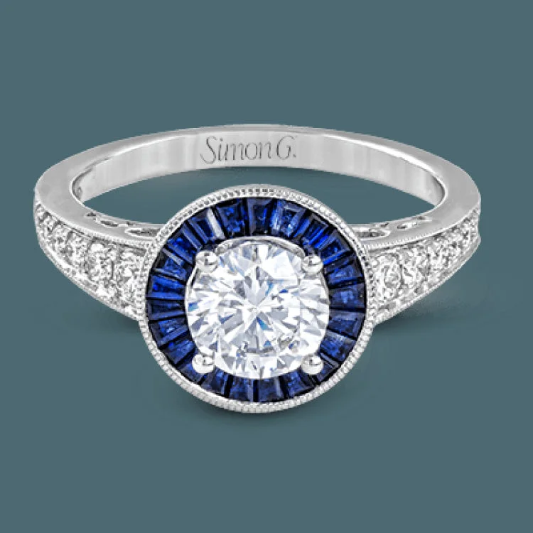 Women’s solitaire engagement rings-This 18k white gold engagement ring add something special with .56 ctw of baguette sapphires in a halo around the center stone. A total of .36 ctw of white diamonds finish this remarkable design.